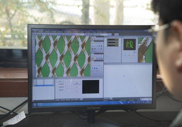 质检员正在检测精密微孔钢板网的性能。